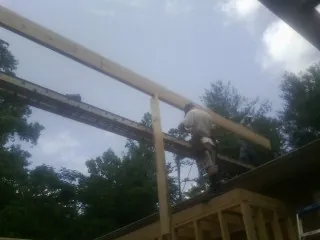 Carpenter setting a ridge beam over a new addition frame — Ice Dam Removal by Roofing Brothers in Delphi