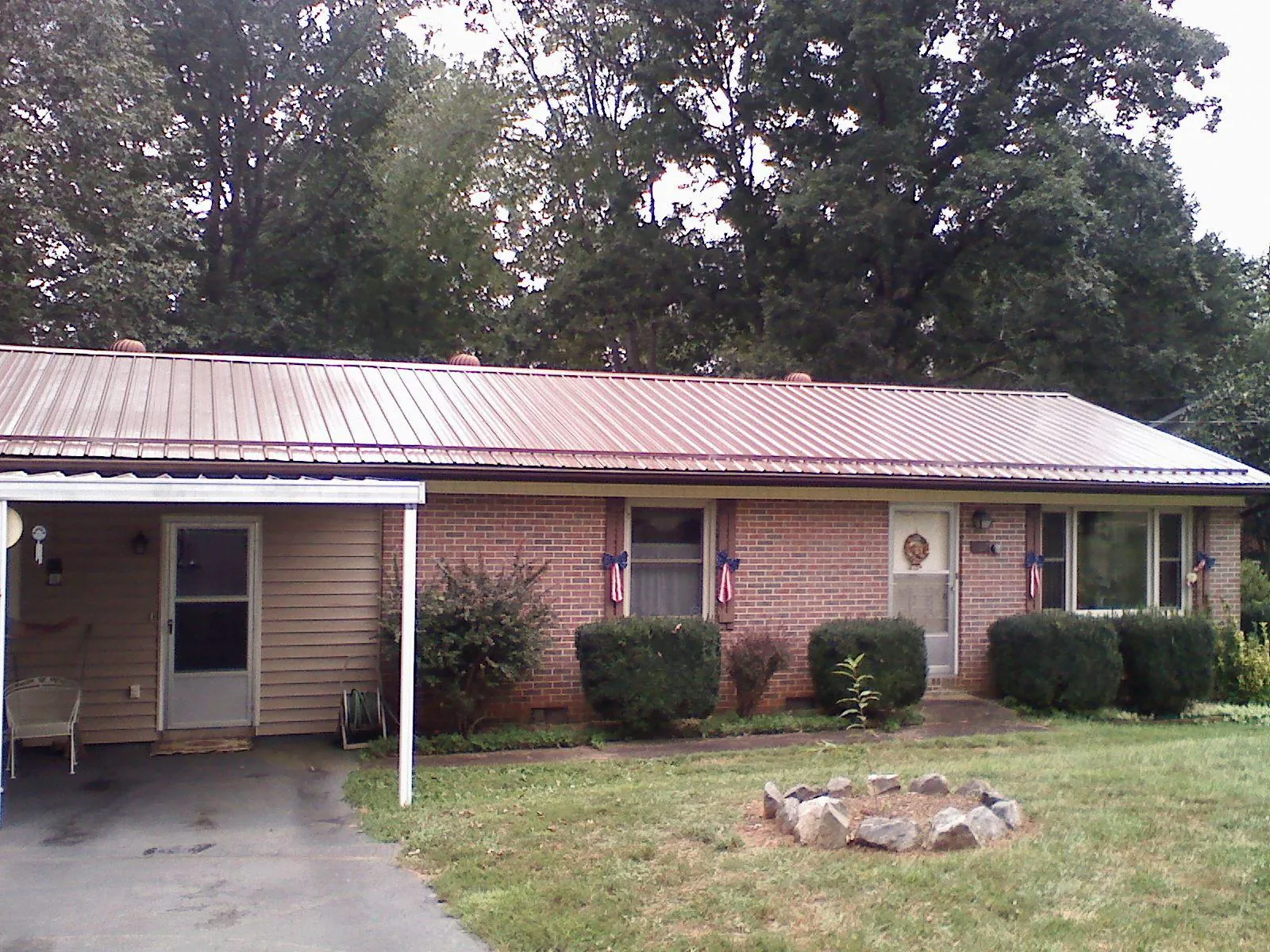 Bronze metal roof and carport on a brick ranch home — Roof Repair work by our crew in Delphi